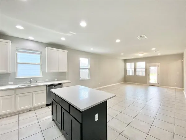 a large kitchen with kitchen island a sink counter space and a window
