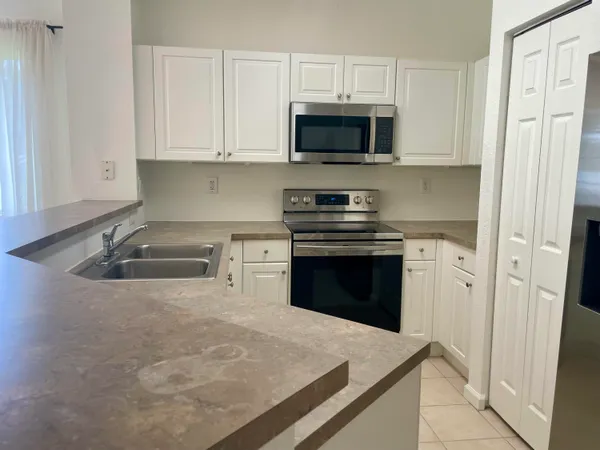 a kitchen with stainless steel appliances a stove a microwave and white cabinets