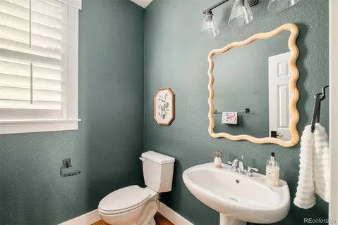 a bathroom with a toilet sink and mirror
