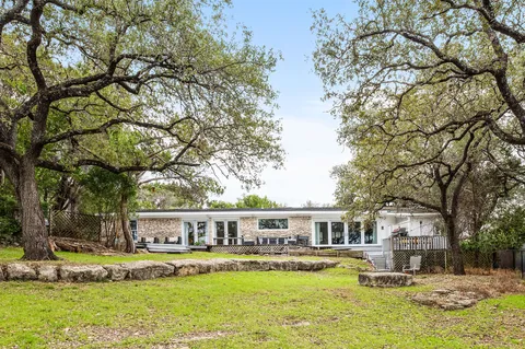 a front view of a house with a yard fountain and a tree