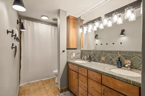 a bathroom with a double vanity sink mirror and shower