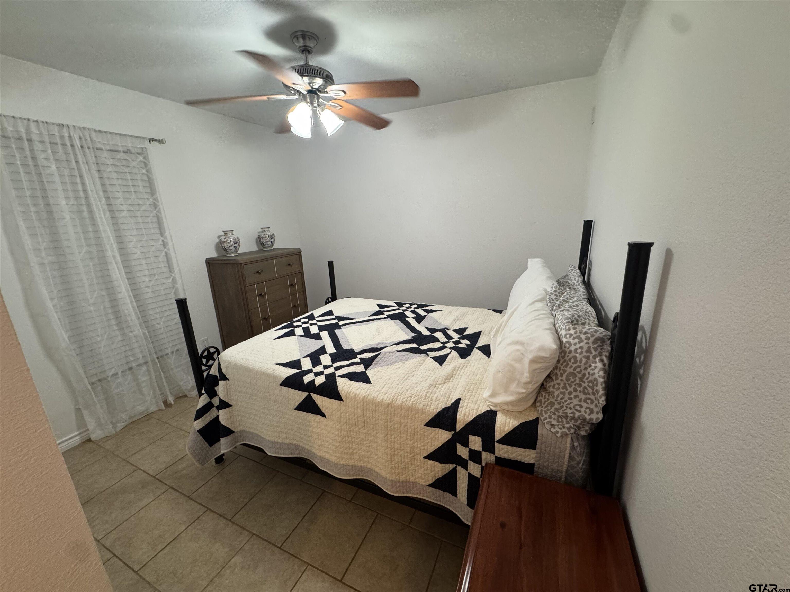 508 County Road 2147 Troup, TX 75789 - Photo 16 of 24 a bedroom with a bed and a chandelier