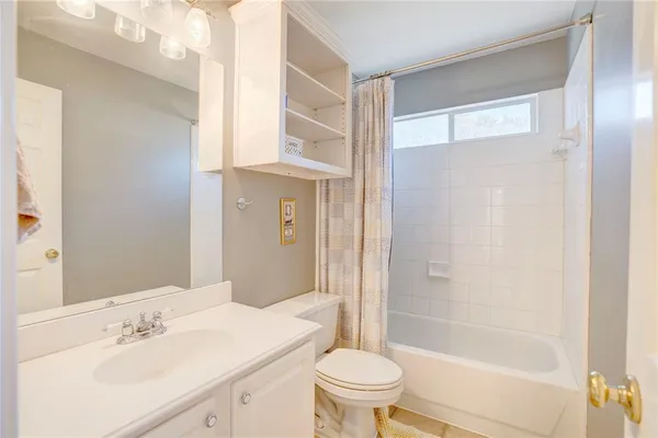 a bathroom with a bathtub shower sink vanity and toilet