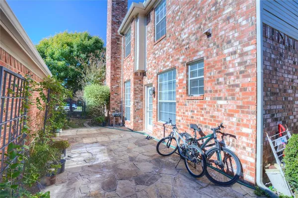 a view of a brick wall with a table and chairs in patio
