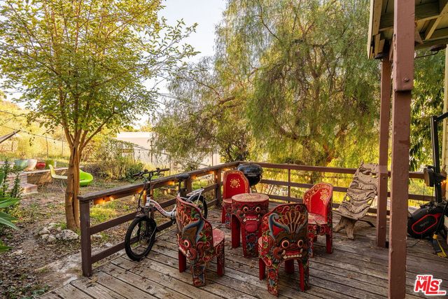 a roof deck with table and chairs and potted plants