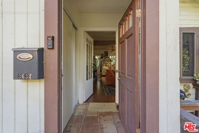 a view of a hallway with wooden floor and a livingroom