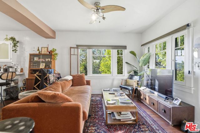 a living room with furniture large window and flat screen tv