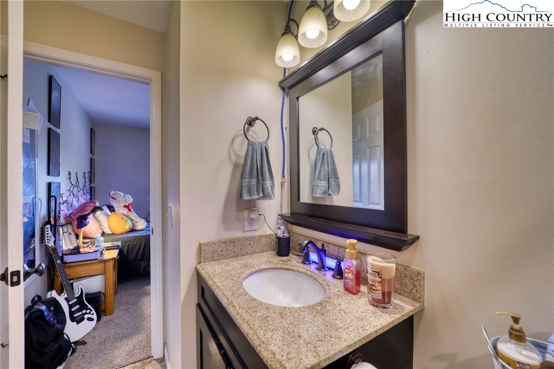 128 Zeb Street, Unit A304 Boone, NC 28607 - Photo 21 of 27 a en suite bathroom with a granite countertop sink and a mirror