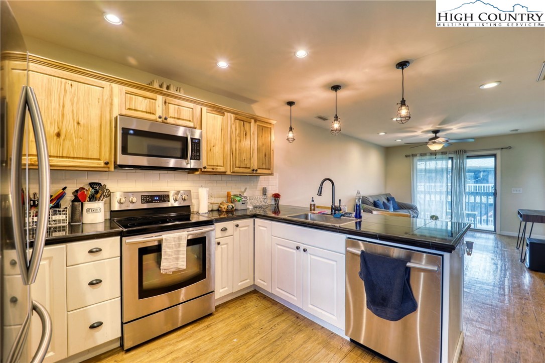 128 Zeb Street, Unit A304 Boone, NC 28607 - Photo 9 of 27 a kitchen with stainless steel appliances granite countertop a sink a stove top oven a counter space and cabinets