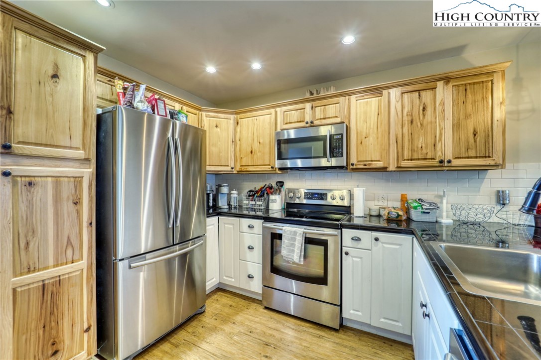 128 Zeb Street, Unit A304 Boone, NC 28607 - Photo 10 of 27 a kitchen with stainless steel appliances granite countertop a refrigerator stove microwave and sink