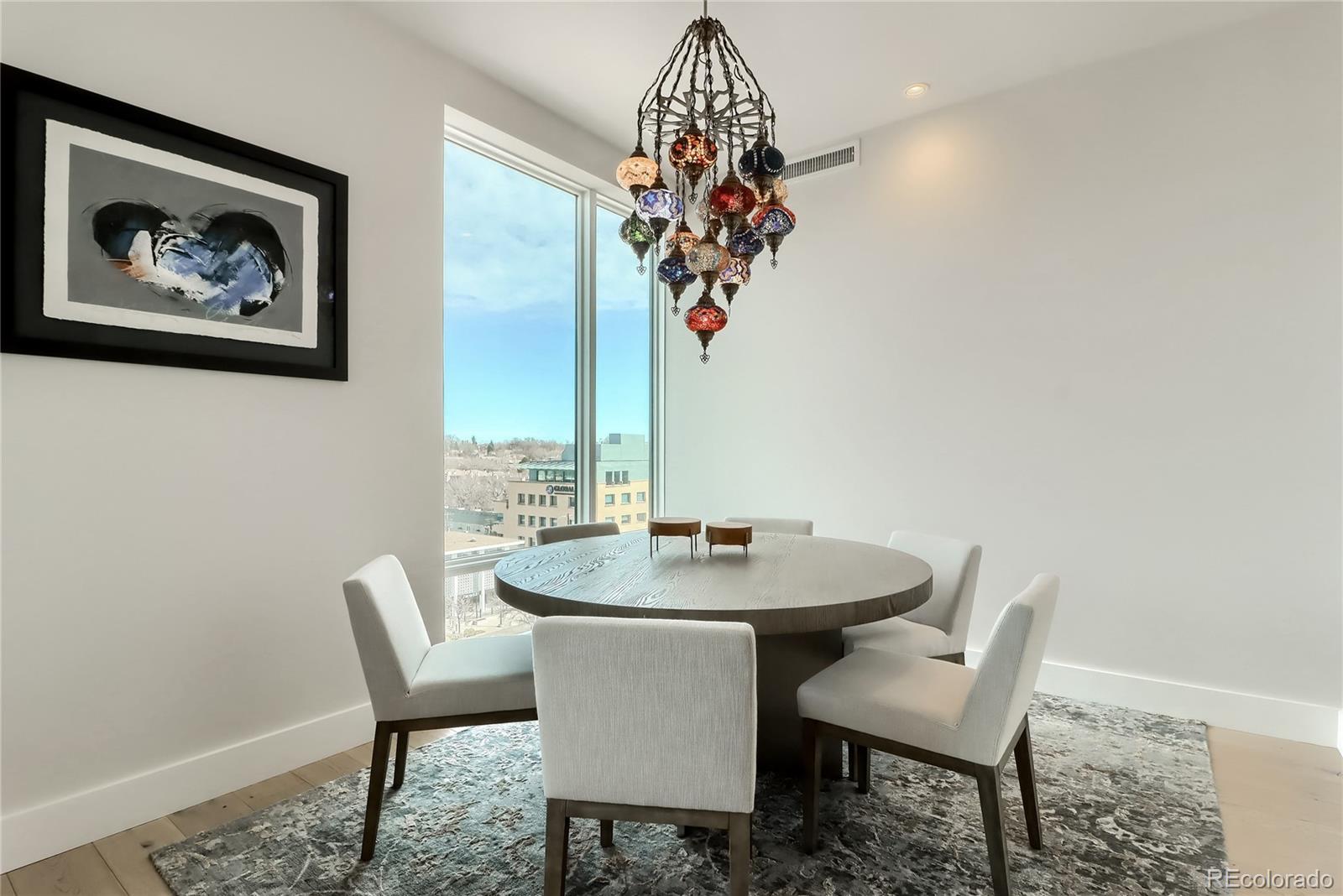155 Steele Street, Unit 814 Denver, CO 80206 - Photo 11 of 39 a view of a dining room with furniture and wooden floor