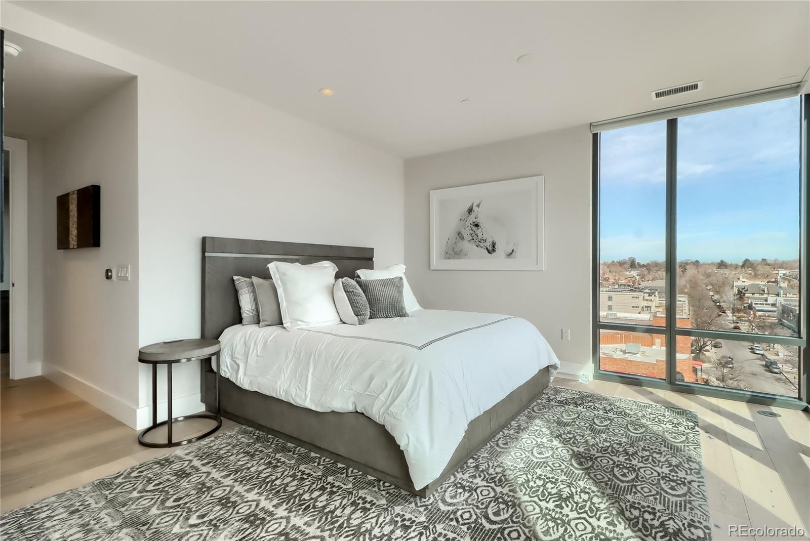 155 Steele Street, Unit 814 Denver, CO 80206 - Photo 14 of 39 a bedroom with a large bed and a tv on table