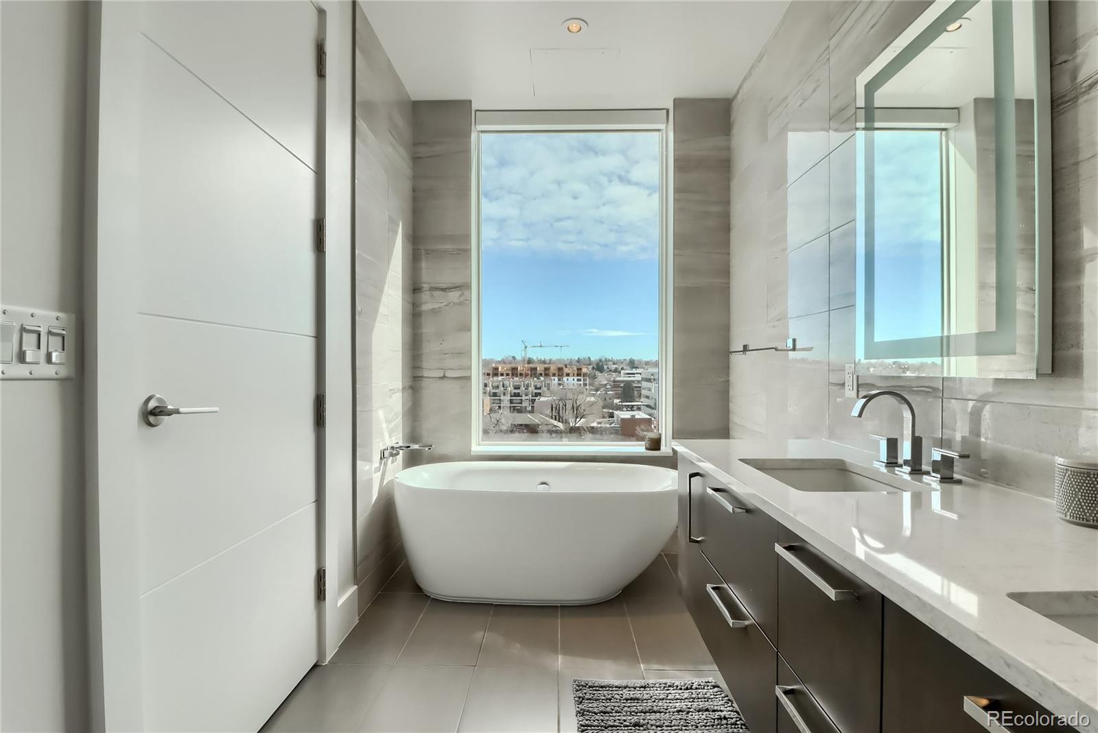 155 Steele Street, Unit 814 Denver, CO 80206 - Photo 17 of 39 a bathroom with a bathtub a sink and a window