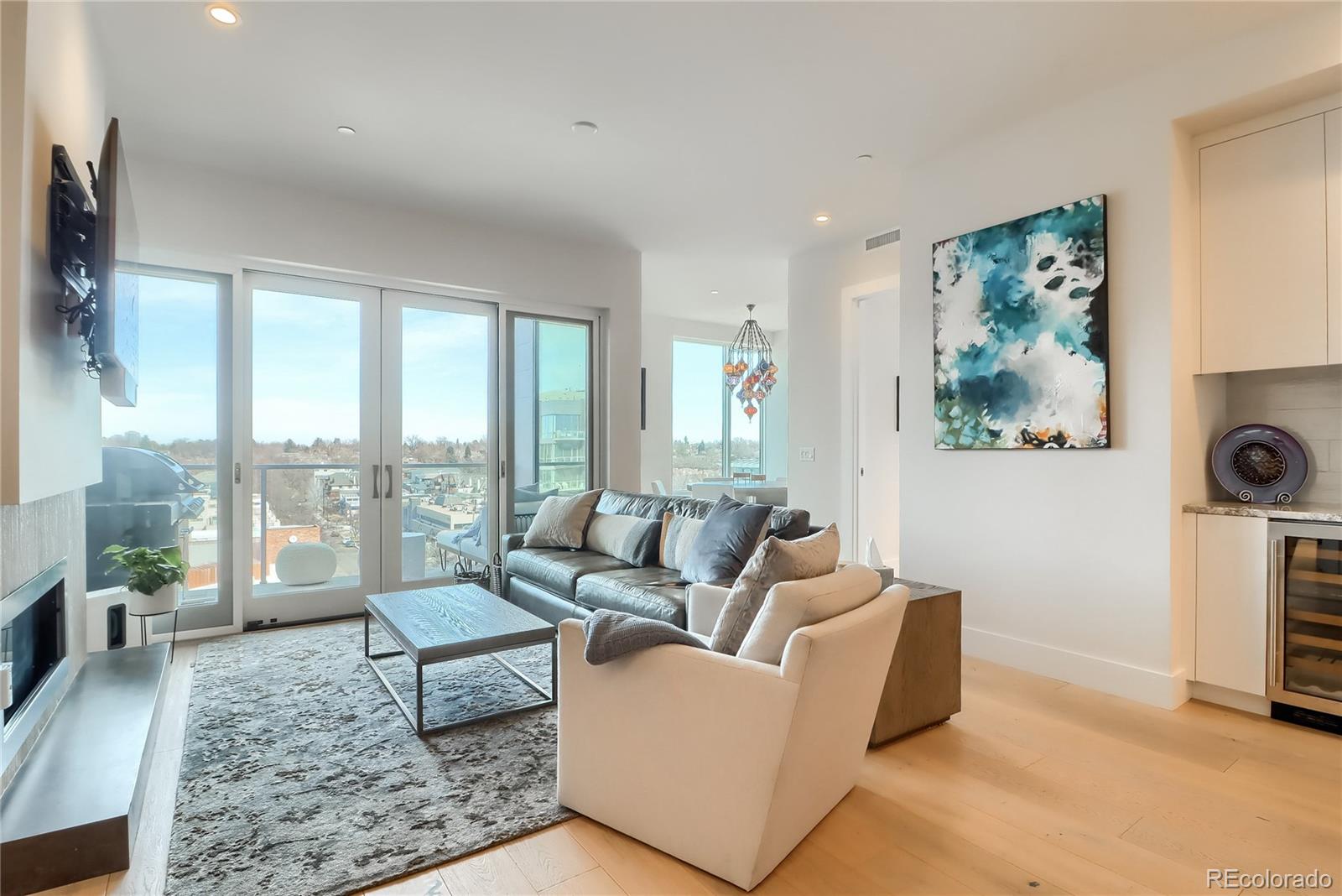 155 Steele Street, Unit 814 Denver, CO 80206 - Photo 2 of 39 a living room with furniture large window and a flat screen tv