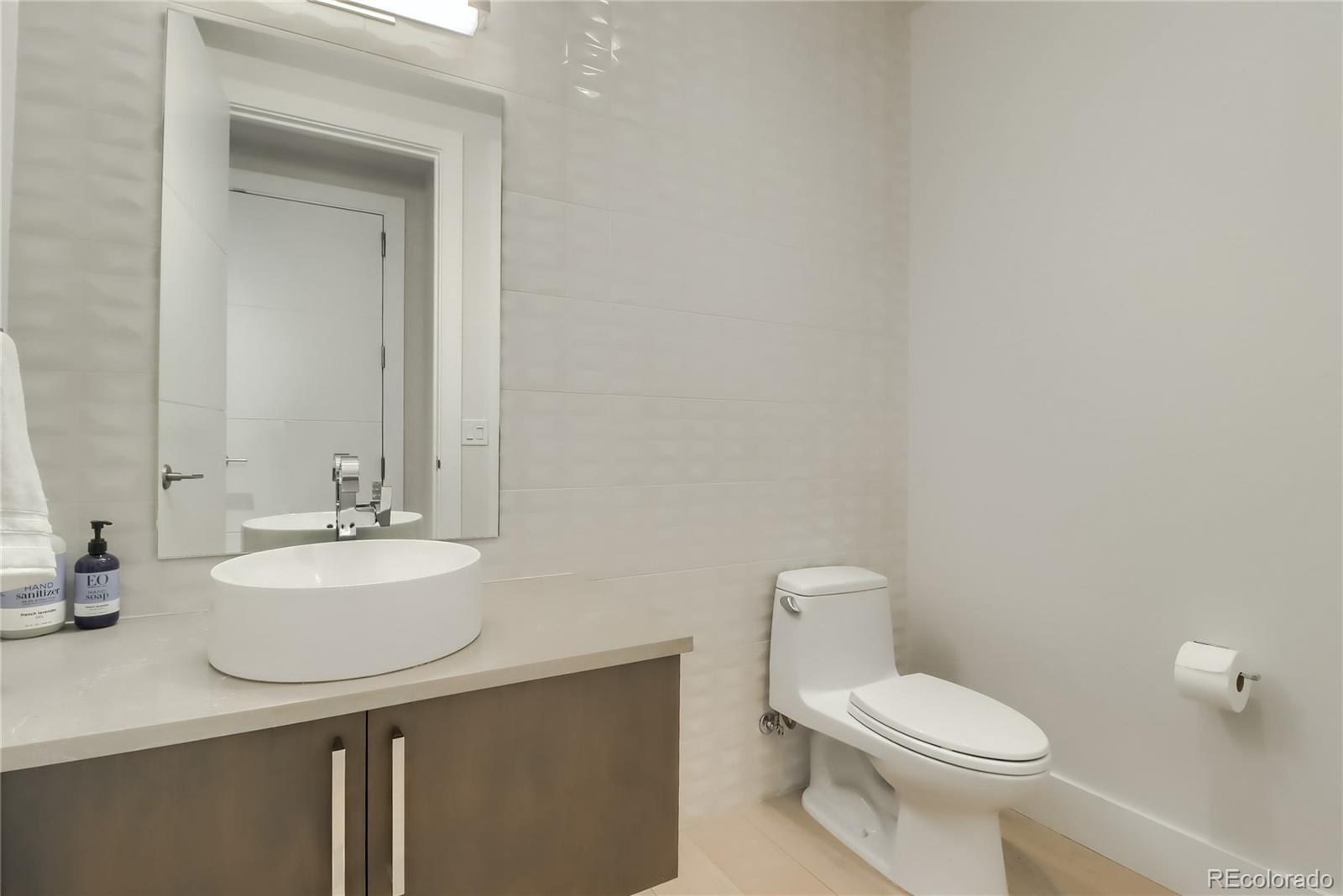 155 Steele Street, Unit 814 Denver, CO 80206 - Photo 22 of 39 a bathroom with a sink a toilet and mirror