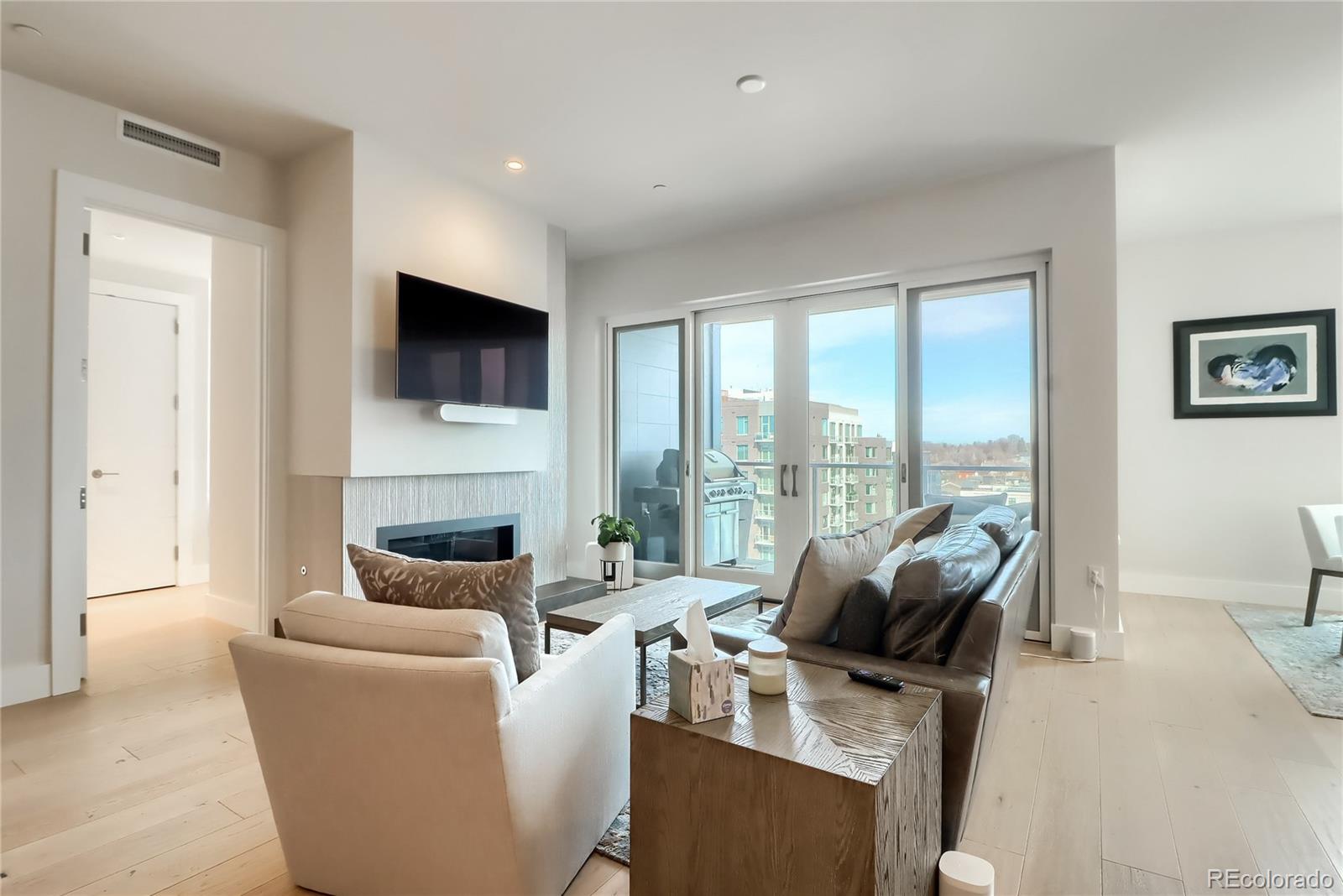 155 Steele Street, Unit 814 Denver, CO 80206 - Photo 3 of 39 a living room with furniture a fireplace and a flat screen tv