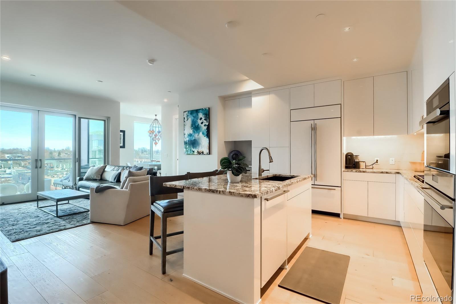 155 Steele Street, Unit 814 Denver, CO 80206 - Photo 8 of 39 a kitchen with a stove top oven a sink and white cabinets