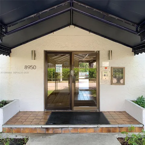 a view of a yard with plants and a large tree