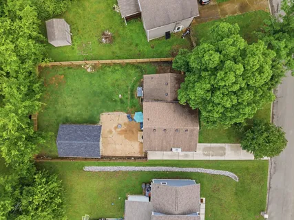 an aerial view of residential houses with outdoor space and trees