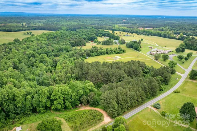 an aerial view of residential houses with outdoor space and trees