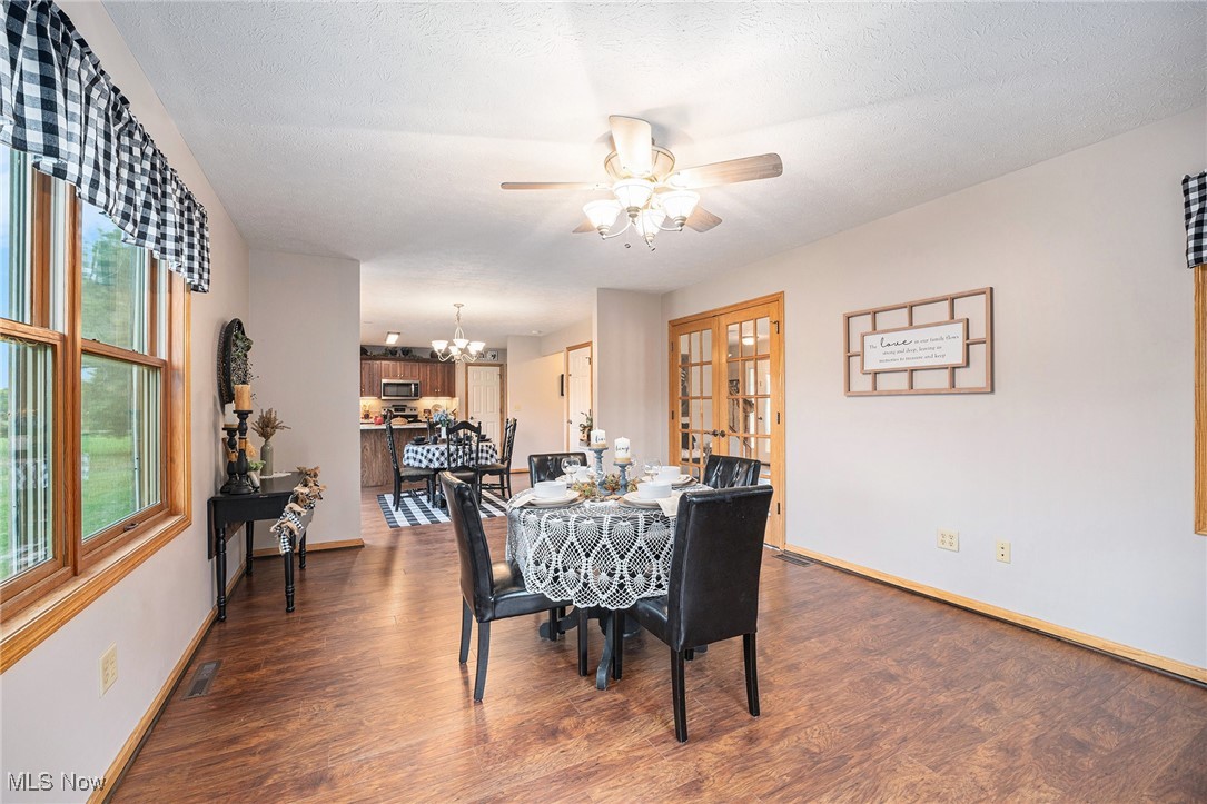2073 Sexton Road Austinburg, OH 44010 - Photo 12 of 32 Dining area with wood finished floors, a chandelier, ceiling fan, and a textured ceiling