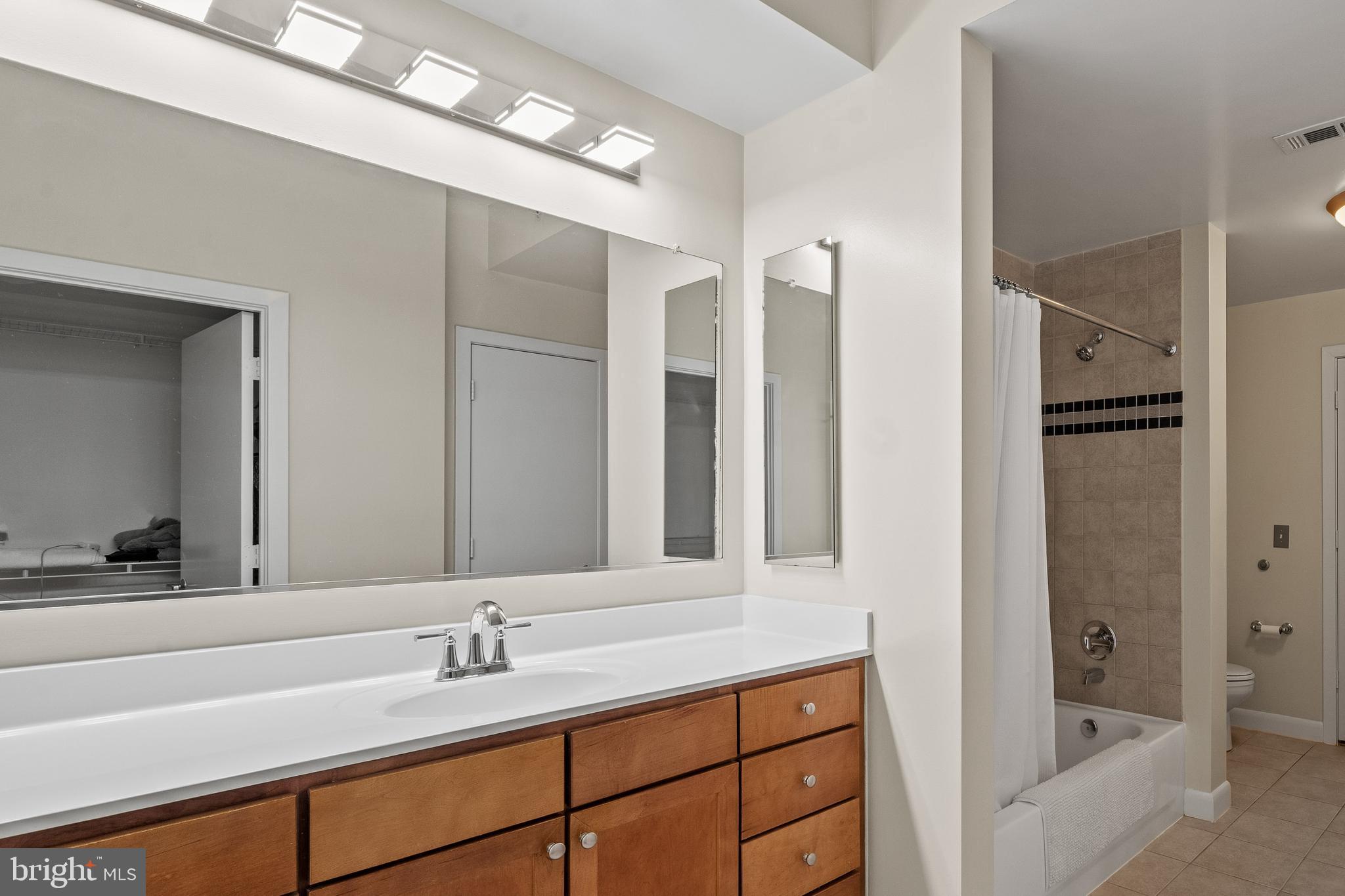 400 Massachusetts Avenue Northwest, Unit 421 Washington, DC 20001 - Photo 22 of 48 a bathroom with a tub sink and mirror