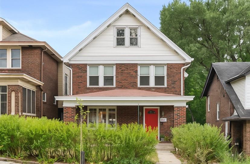 a view of a white house next to a yard