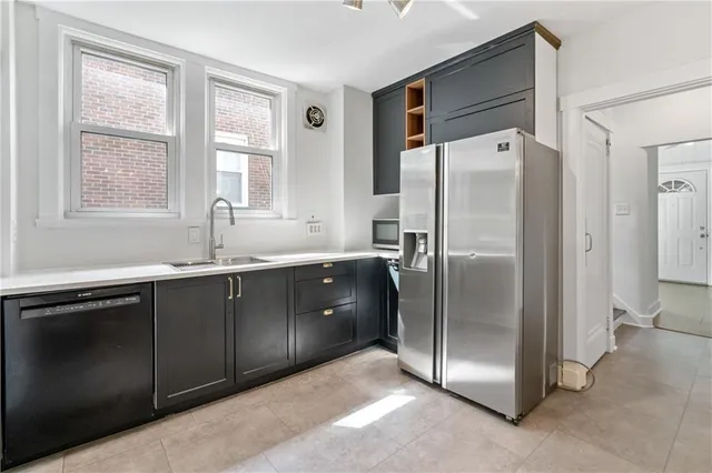 a kitchen with stainless steel appliances granite countertop a refrigerator and a sink