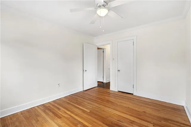 a view of a room with wooden floor and ceiling fan