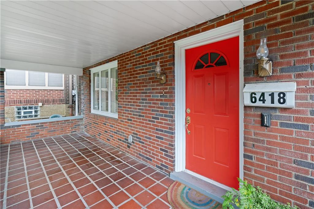 6418 Landview Road Pittsburgh, PA 15217 - Photo 3 of 45 a front view of a building with a red door and a potted plant