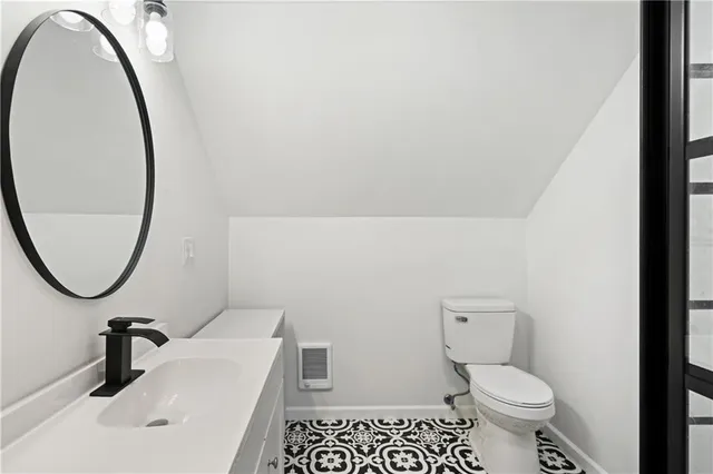 a bathroom with a sink toilet and a mirror