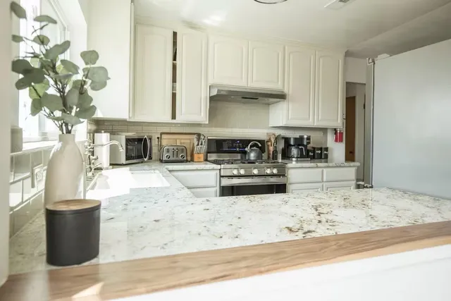 a kitchen with stainless steel appliances kitchen island granite countertop a sink and cabinets