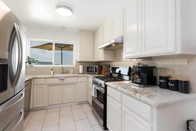 a kitchen with a sink a stove and cabinets
