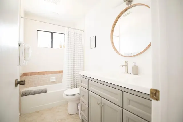 a bathroom with a sink a toilet and a mirror