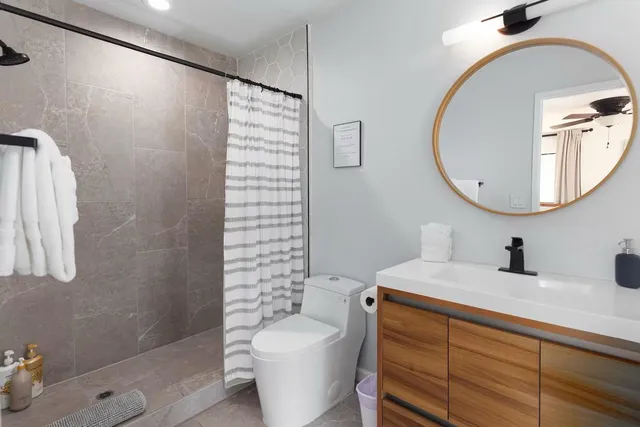 a bathroom with a sink a toilet and shower