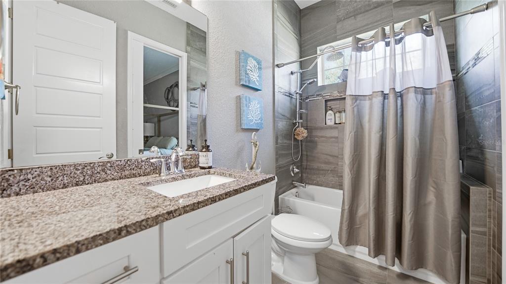 4 Flagship Court Palm Coast, FL 32137 - Photo 36 of 64 a bathroom with a granite countertop sink toilet and shower