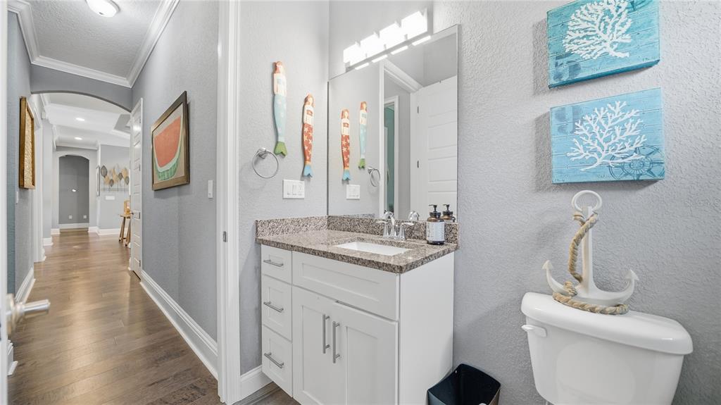 4 Flagship Court Palm Coast, FL 32137 - Photo 37 of 64 a bathroom with a granite countertop sink a toilet and a mirror