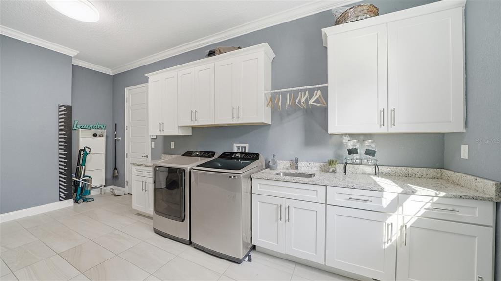 4 Flagship Court Palm Coast, FL 32137 - Photo 44 of 64 a kitchen with stainless steel appliances granite countertop a stove a sink and white cabinets