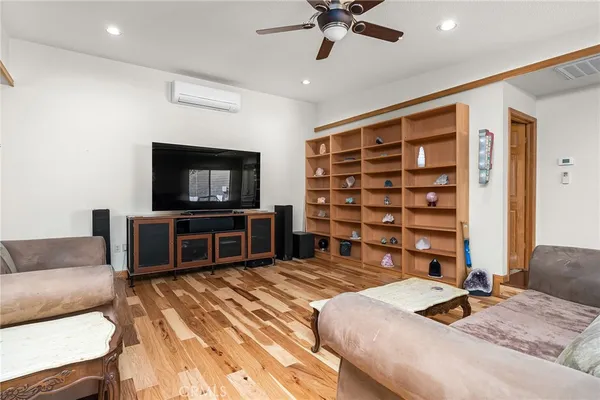 a living room with furniture a ceiling fan and a window