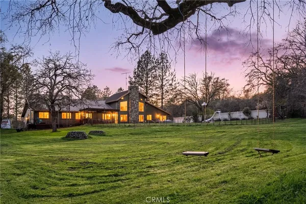 a view of a house with a big yard and a large tree