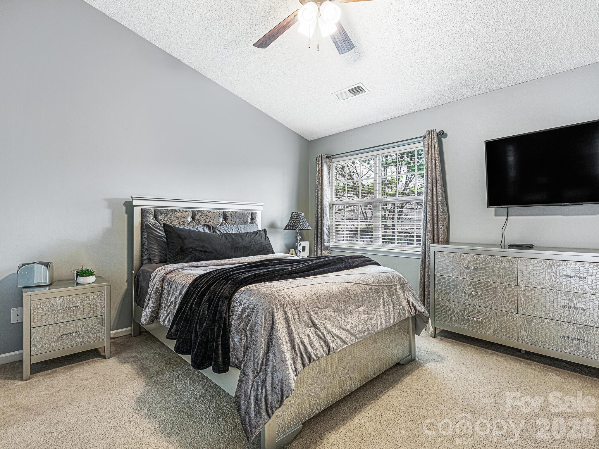 10783 Holly Ridge Boulevard Charlotte, NC 28216 - Photo 12 of 20 a bedroom with a bed and a flat screen tv