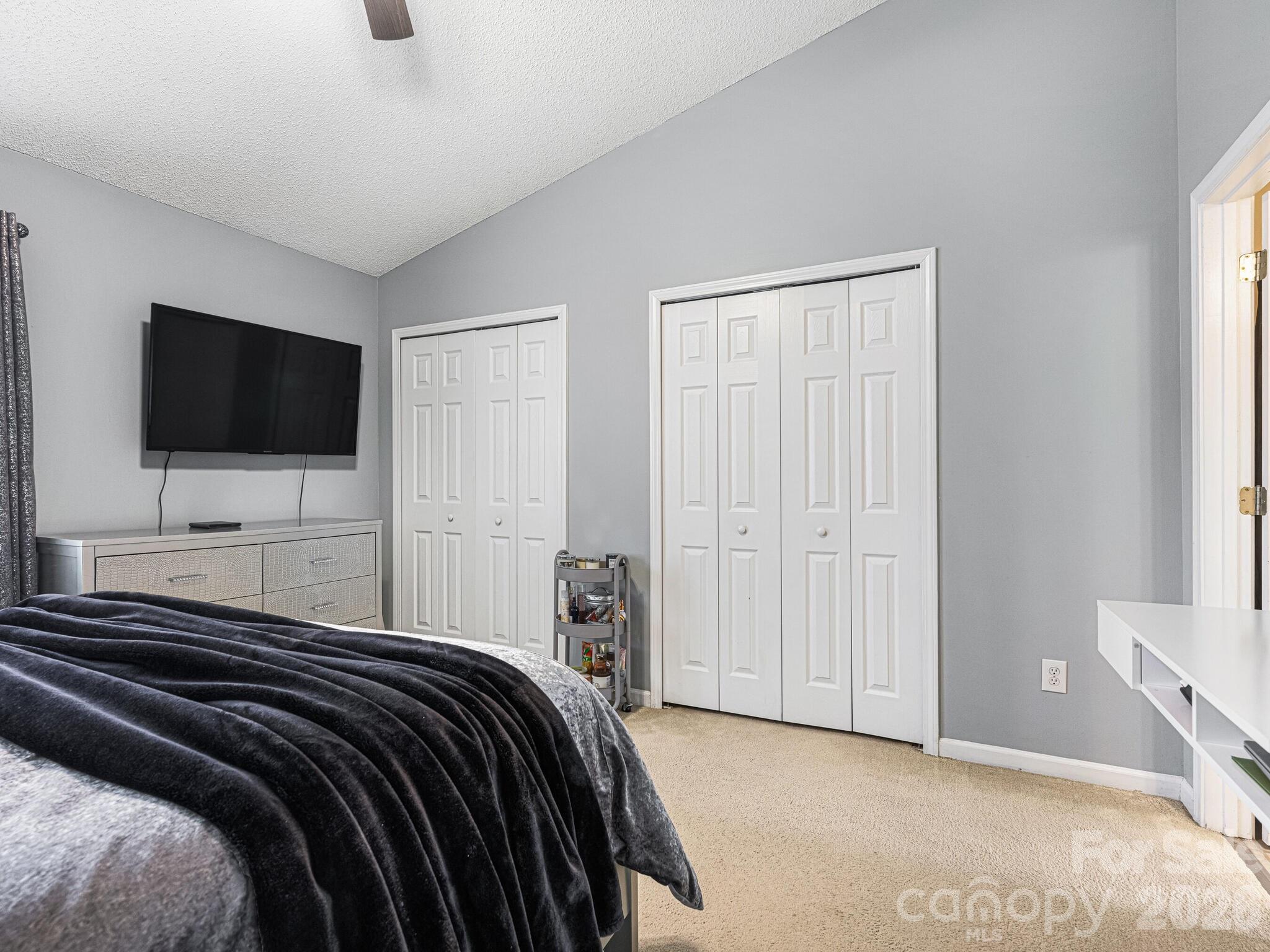 10783 Holly Ridge Boulevard Charlotte, NC 28216 - Photo 13 of 20 a bedroom with a bed and a flat screen tv