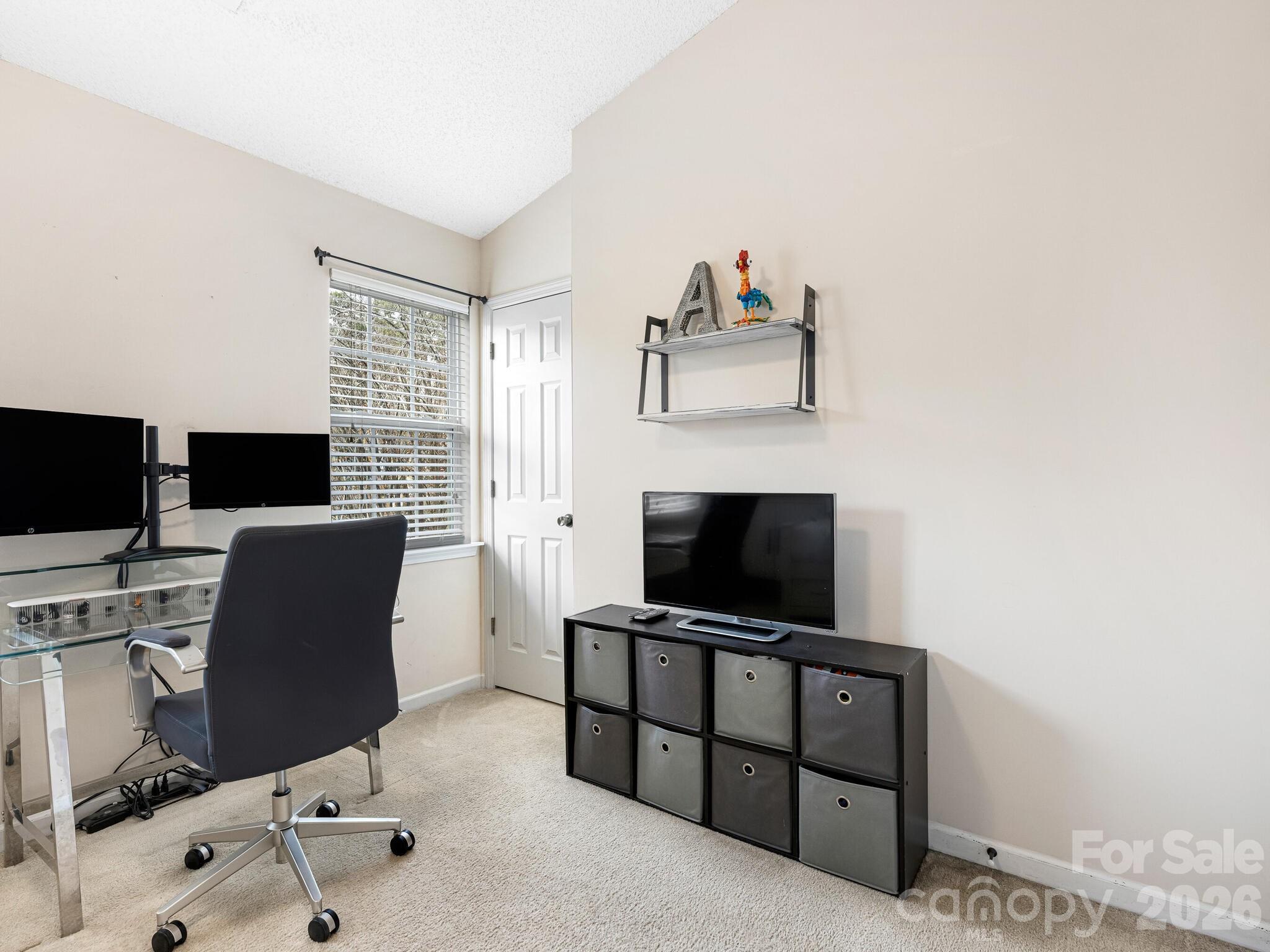 10783 Holly Ridge Boulevard Charlotte, NC 28216 - Photo 17 of 20 a view of a workspace with a flat screen tv and a window