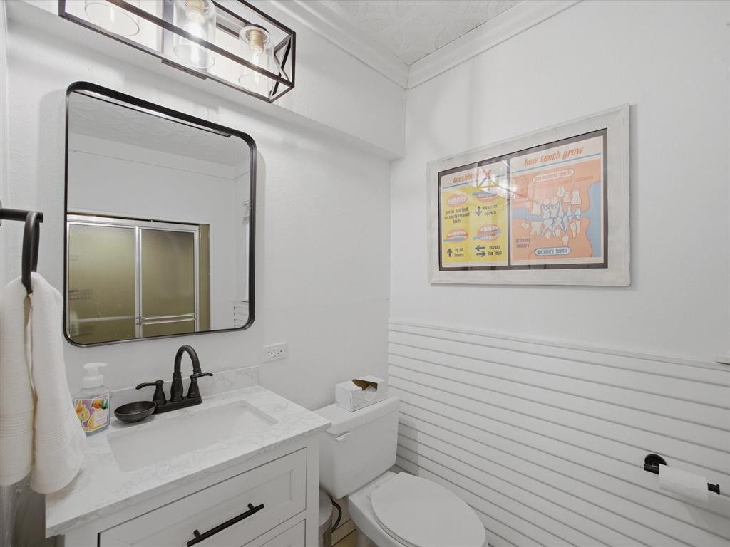 907 4th Street Graham, TX 76450 - Photo 12 of 34 a bathroom with a toilet sink and mirror