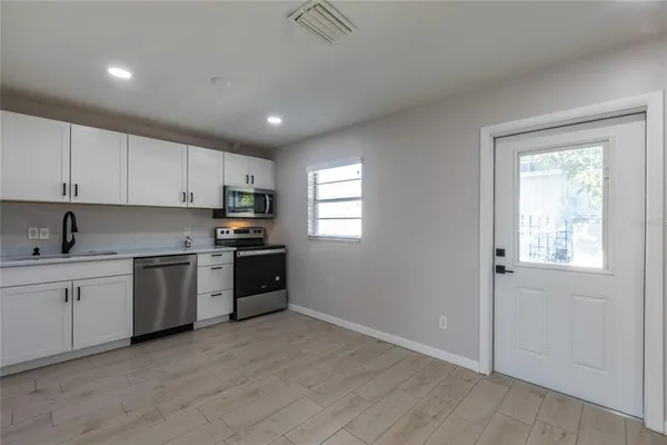 a kitchen with granite countertop white cabinets and stainless steel appliances