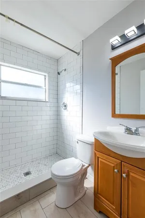 a bathroom with a sink a toilet and shower