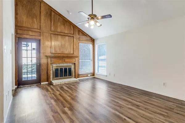 a view of a livingroom with a fireplace a ceiling fan and brick wall