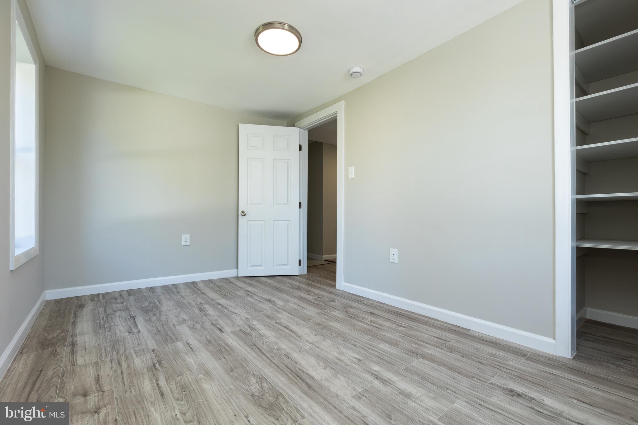 2407 Hammonds Ferry Road Halethorpe, MD 21227 - Photo 35 of 43 an empty room with wooden floor and windows