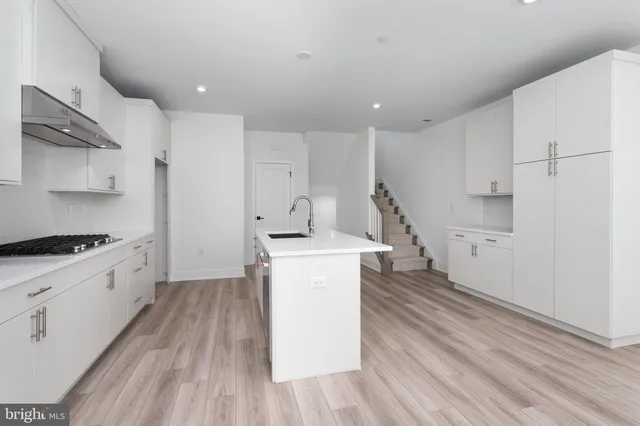 a kitchen with wooden floors and white appliances