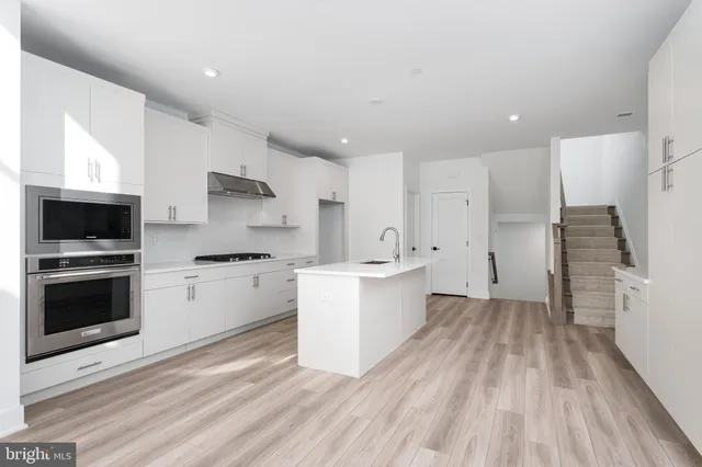 a kitchen with a sink stainless steel appliances and cabinets